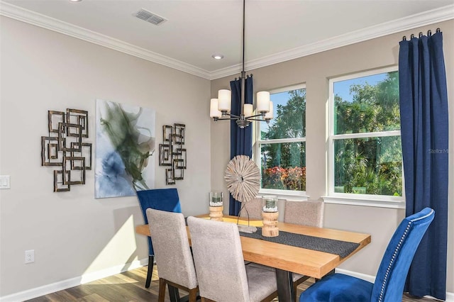 dining space with visible vents, baseboards, ornamental molding, an inviting chandelier, and wood finished floors