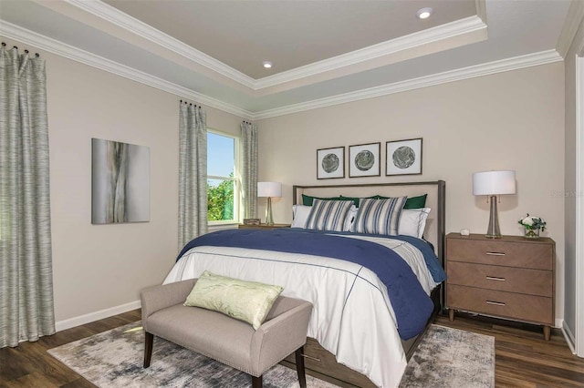 bedroom with baseboards, a raised ceiling, and wood finished floors