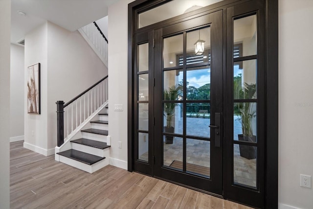 entrance foyer featuring stairway, baseboards, and wood finished floors