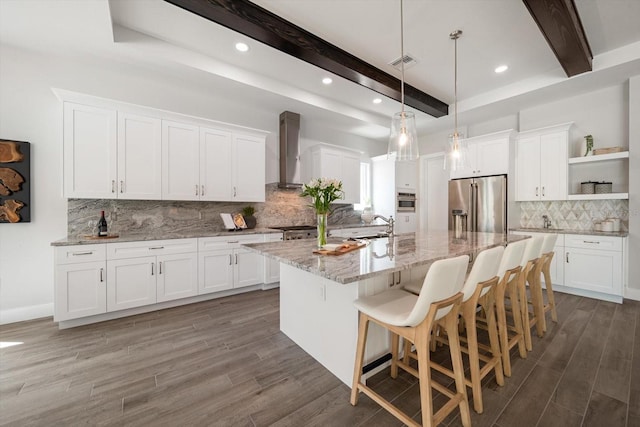 kitchen featuring open shelves, white cabinets, beamed ceiling, wall chimney exhaust hood, and high quality fridge