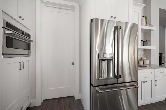 kitchen with dark wood-type flooring, light stone countertops, appliances with stainless steel finishes, white cabinets, and open shelves