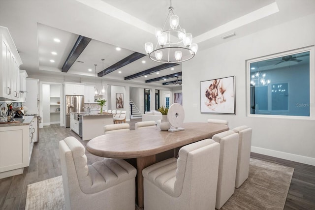 dining room with visible vents, baseboards, light wood-type flooring, beam ceiling, and ceiling fan with notable chandelier