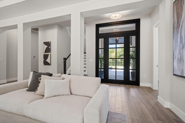 entryway featuring stairs, baseboards, and wood finished floors