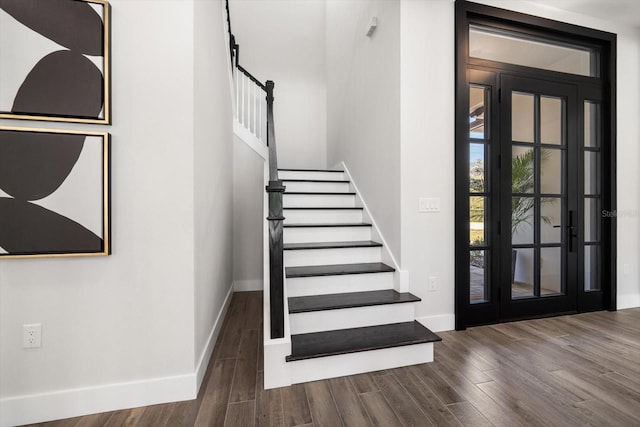 staircase featuring baseboards and wood finished floors