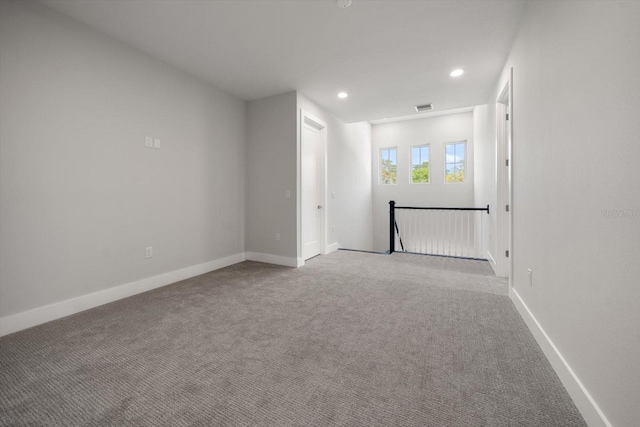 carpeted empty room featuring recessed lighting, visible vents, and baseboards