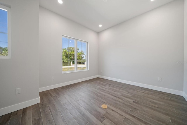 spare room featuring recessed lighting, dark wood-style floors, and baseboards