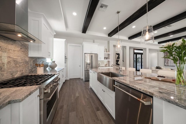 kitchen featuring visible vents, a sink, dark wood-style floors, stainless steel appliances, and wall chimney exhaust hood