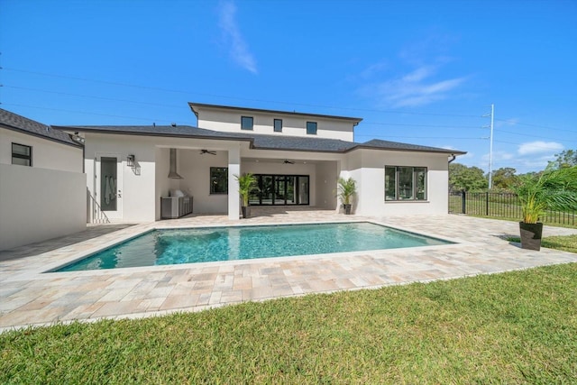 rear view of property featuring a patio, a fenced in pool, a ceiling fan, fence, and stucco siding