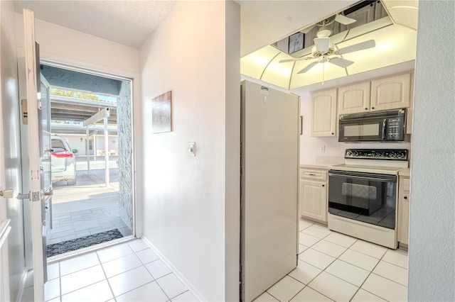 kitchen featuring black microwave, freestanding refrigerator, white electric range oven, light tile patterned flooring, and a ceiling fan