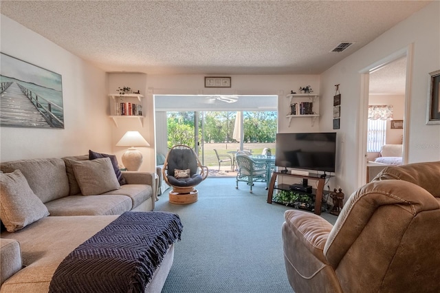 carpeted living room with visible vents and a textured ceiling