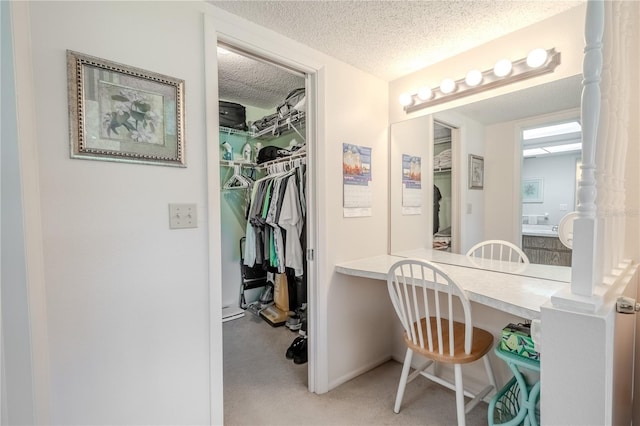 bathroom with a textured ceiling and a spacious closet