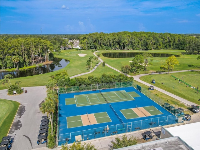 bird's eye view with view of golf course, a wooded view, and a water view