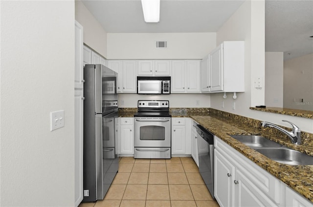 kitchen featuring light tile patterned flooring, white cabinets, visible vents, appliances with stainless steel finishes, and a sink
