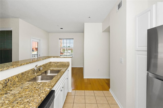 kitchen with light tile patterned flooring, visible vents, stainless steel appliances, a sink, and light stone counters