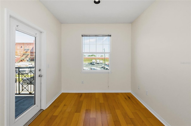 empty room featuring baseboards and light wood-type flooring