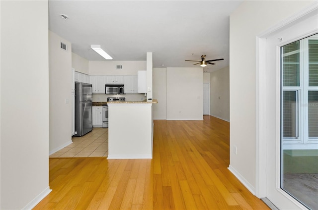 kitchen with white cabinets, visible vents, ceiling fan, appliances with stainless steel finishes, and light wood-style floors