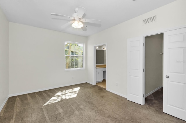 unfurnished bedroom with baseboards, carpet floors, ensuite bath, visible vents, and a closet