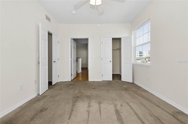 unfurnished bedroom featuring baseboards, visible vents, carpet floors, and a ceiling fan