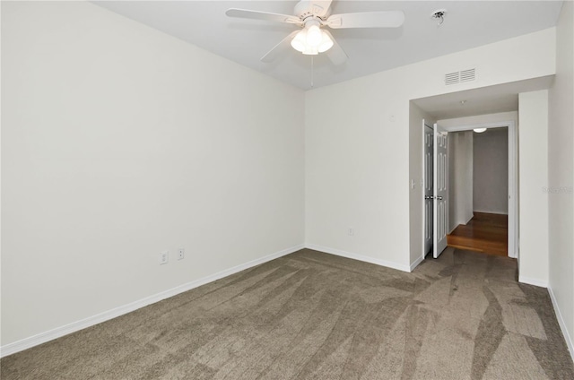 unfurnished room with baseboards, visible vents, carpet flooring, and a ceiling fan