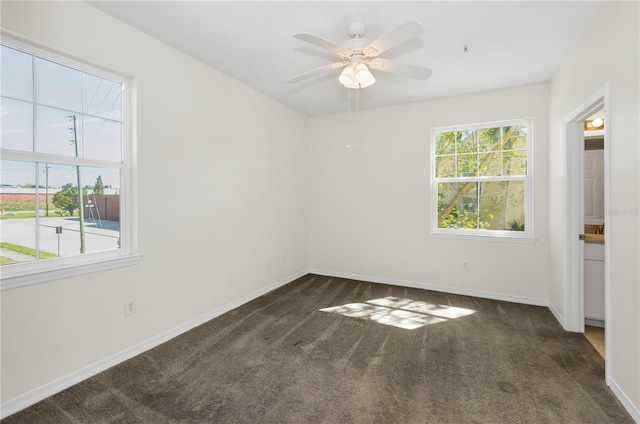 carpeted empty room with a ceiling fan and baseboards