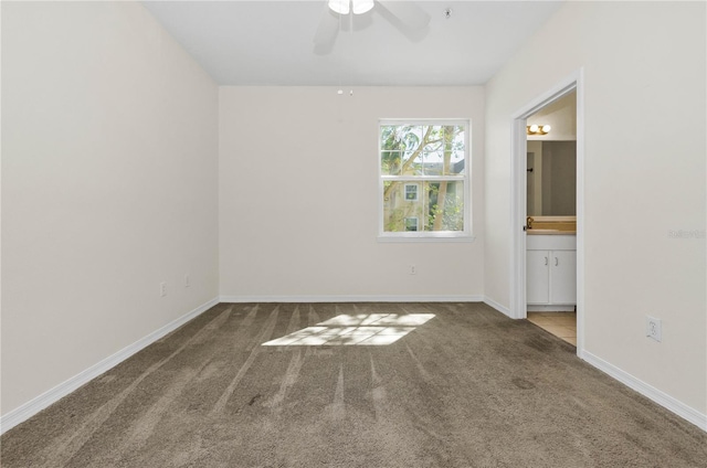 unfurnished bedroom with baseboards, ensuite bath, ceiling fan, and carpet