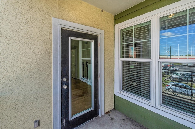 view of exterior entry featuring stucco siding
