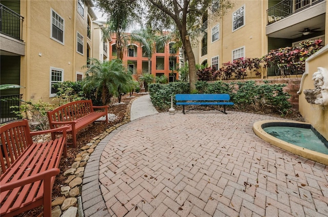 view of property's community featuring a patio area and a hot tub