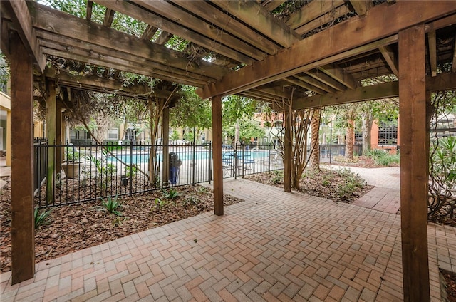 view of patio / terrace with a community pool, a pergola, and fence