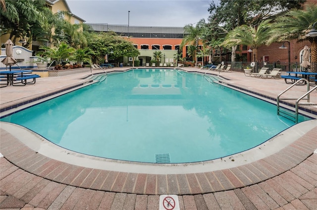 community pool featuring fence and a patio area