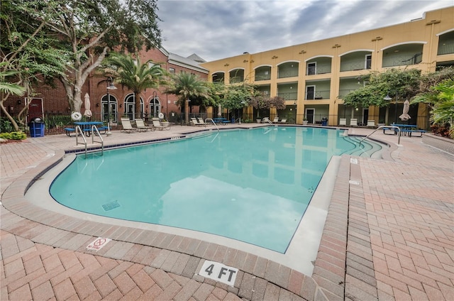 pool featuring fence and a patio