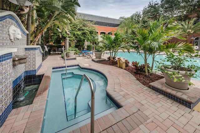 pool with a hot tub and a patio