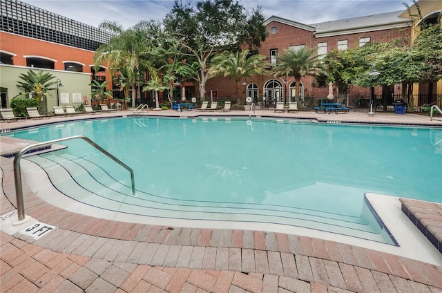 pool with fence and a patio area