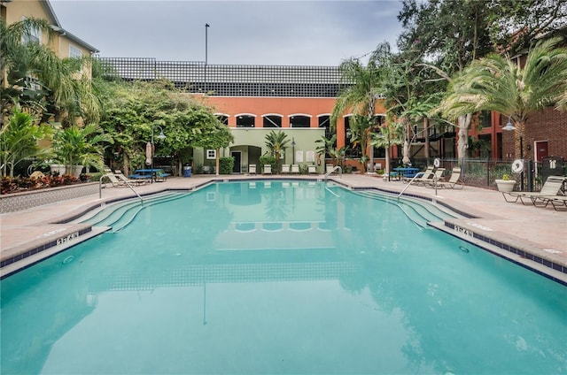 pool featuring fence and a patio area