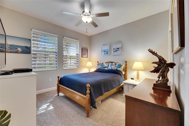 bedroom featuring light colored carpet, baseboards, and ceiling fan