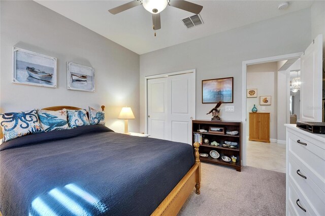 bedroom featuring visible vents, light colored carpet, a closet, and a ceiling fan