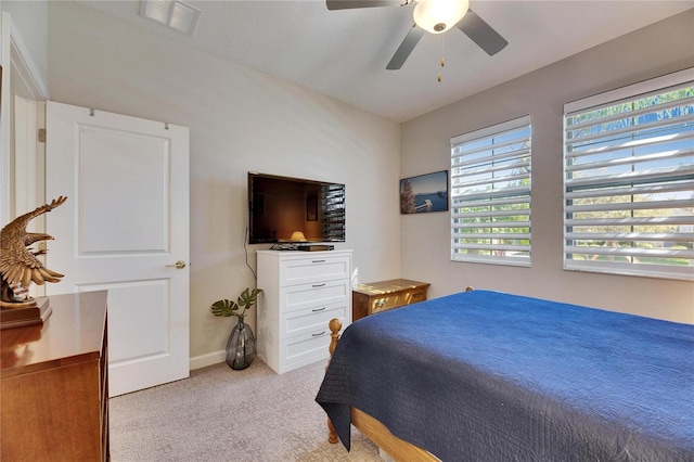 bedroom featuring light carpet, visible vents, baseboards, and ceiling fan