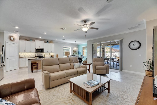 living room featuring light tile patterned floors, visible vents, and ornamental molding