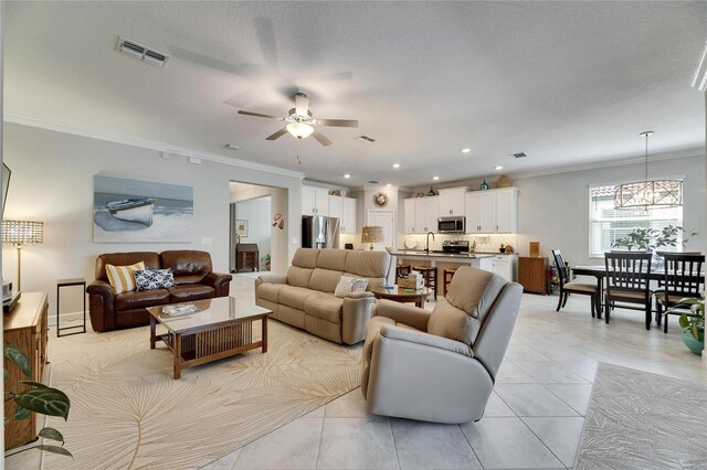 living room featuring visible vents, crown molding, light tile patterned floors, recessed lighting, and ceiling fan with notable chandelier