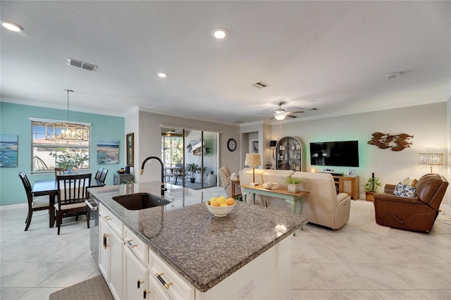 kitchen with visible vents, crown molding, and a sink