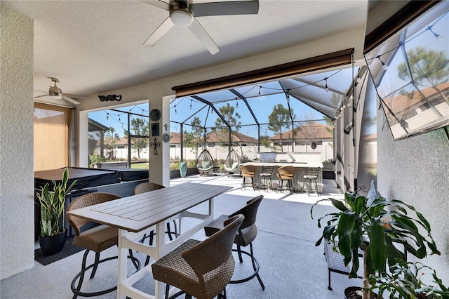 view of patio / terrace featuring a lanai, outdoor dining space, a ceiling fan, and fence