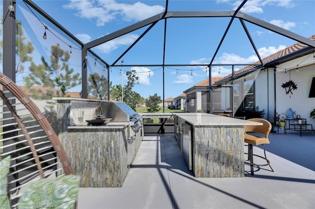 view of patio / terrace featuring a lanai, area for grilling, and outdoor dry bar