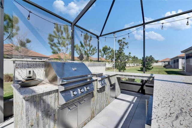 view of patio with a lanai, area for grilling, and a grill