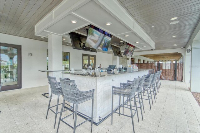 kitchen featuring a breakfast bar area, recessed lighting, light floors, and a healthy amount of sunlight