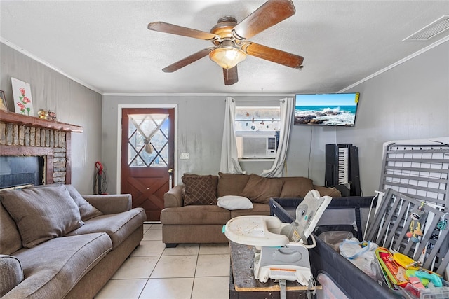 living room featuring visible vents, a textured ceiling, a fireplace, crown molding, and light tile patterned floors