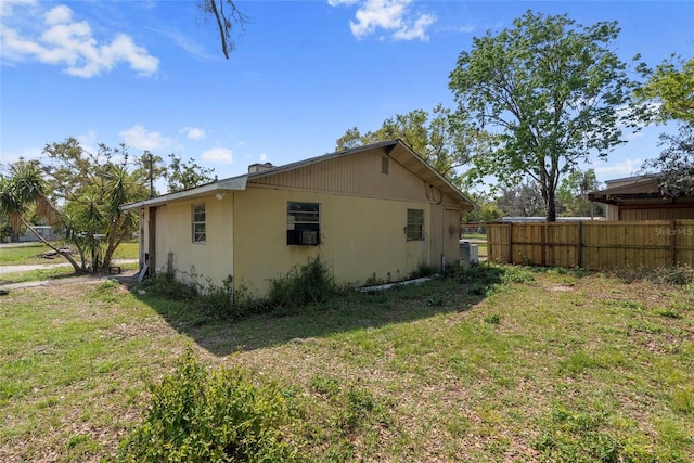 view of side of home with a yard and fence