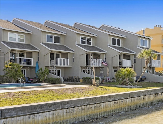 multi unit property with a residential view, stucco siding, and a fenced in pool