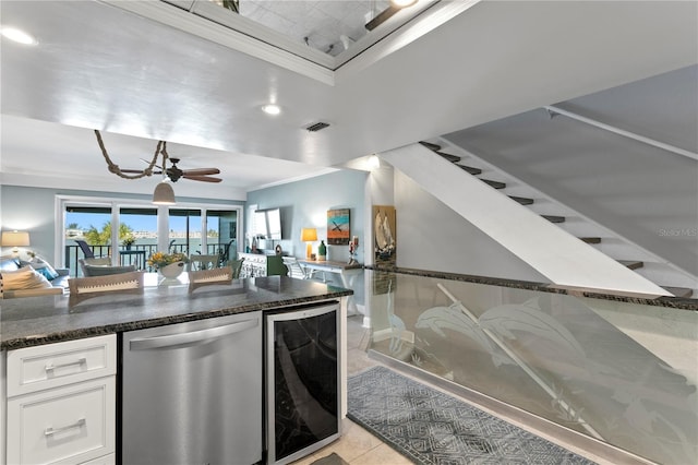 kitchen featuring beverage cooler, visible vents, white cabinets, stainless steel dishwasher, and crown molding