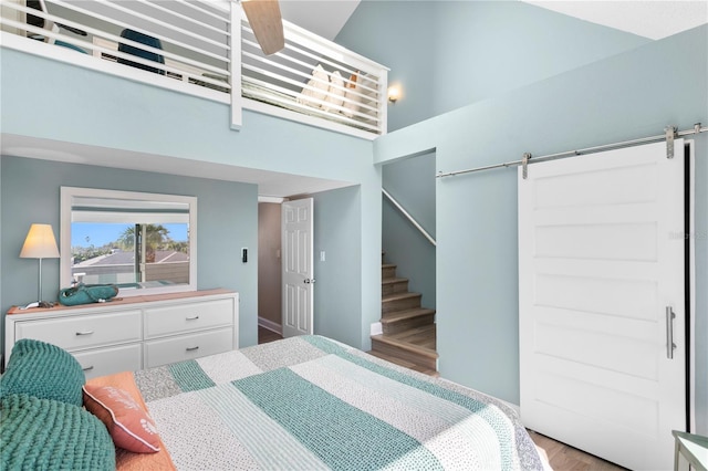 bedroom with a barn door and a towering ceiling