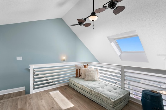 sitting room featuring baseboards, lofted ceiling, and wood finished floors