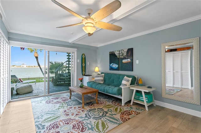 living room featuring beamed ceiling, ornamental molding, wood finished floors, baseboards, and ceiling fan